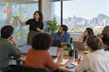 Facilitador apresenta um quadro de post-its coloridos para equipe com notebooks em sala de treinamento