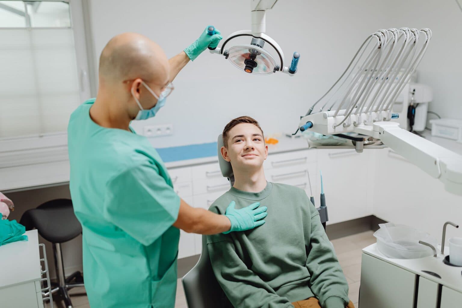 Dentista atendendo paciente sorridente em consultório odontológico moderno