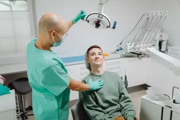Dentista atendendo paciente sorridente em consultório odontológico moderno