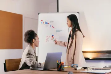Consultora revisando un flujo de trabajo con IA junto a cliente PyME.